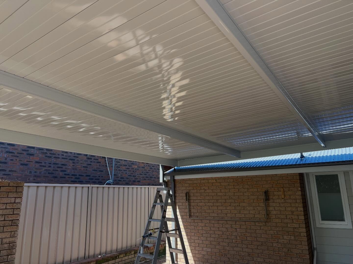 Insulated patio ceiling panels above a brick courtyard