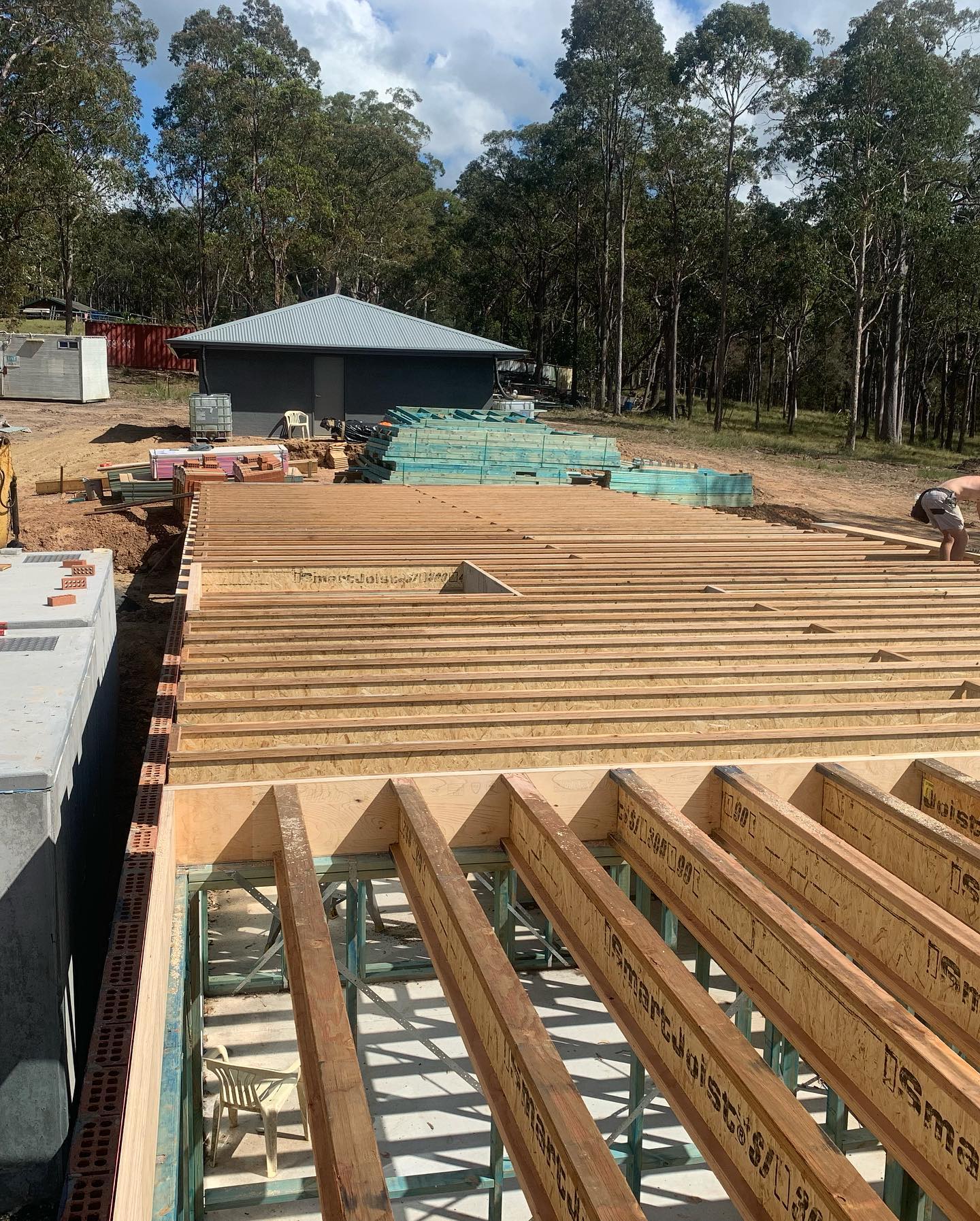 Engineered floor joists laid over a steel frame on a rural building site