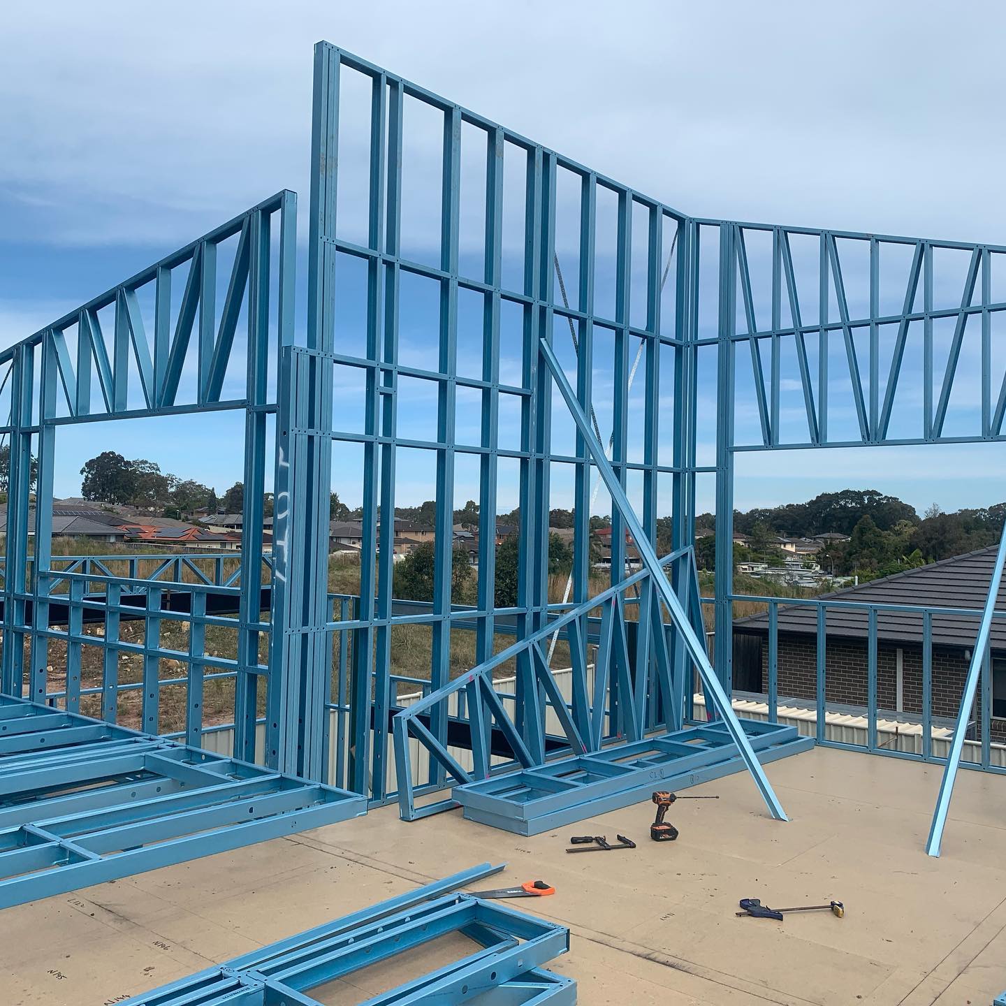 Steel wall frames braced on an upper floor slab of a new home