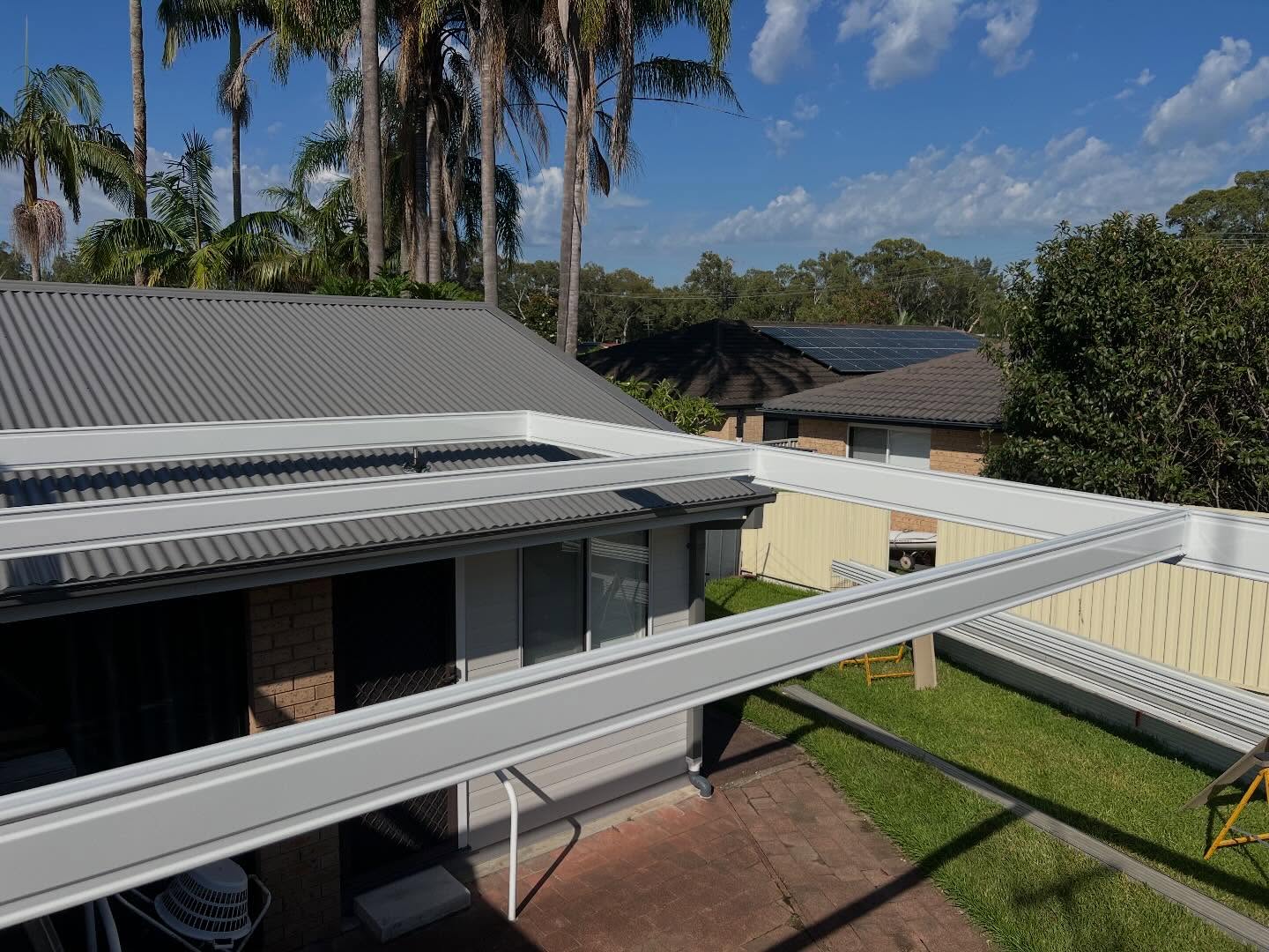 New awning beams set out above a tiled roof and backyard