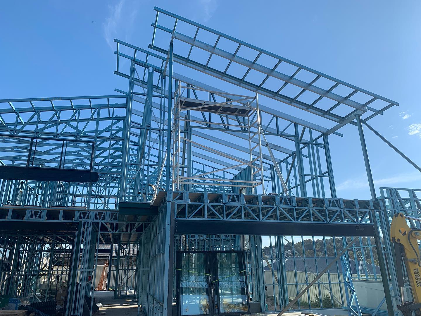 Steel frame of a two storey home standing against a clear sky